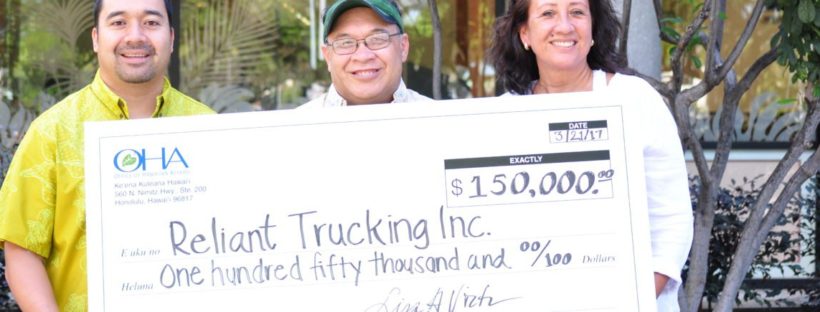 Photo: Reliant Trucking Owners holding a check